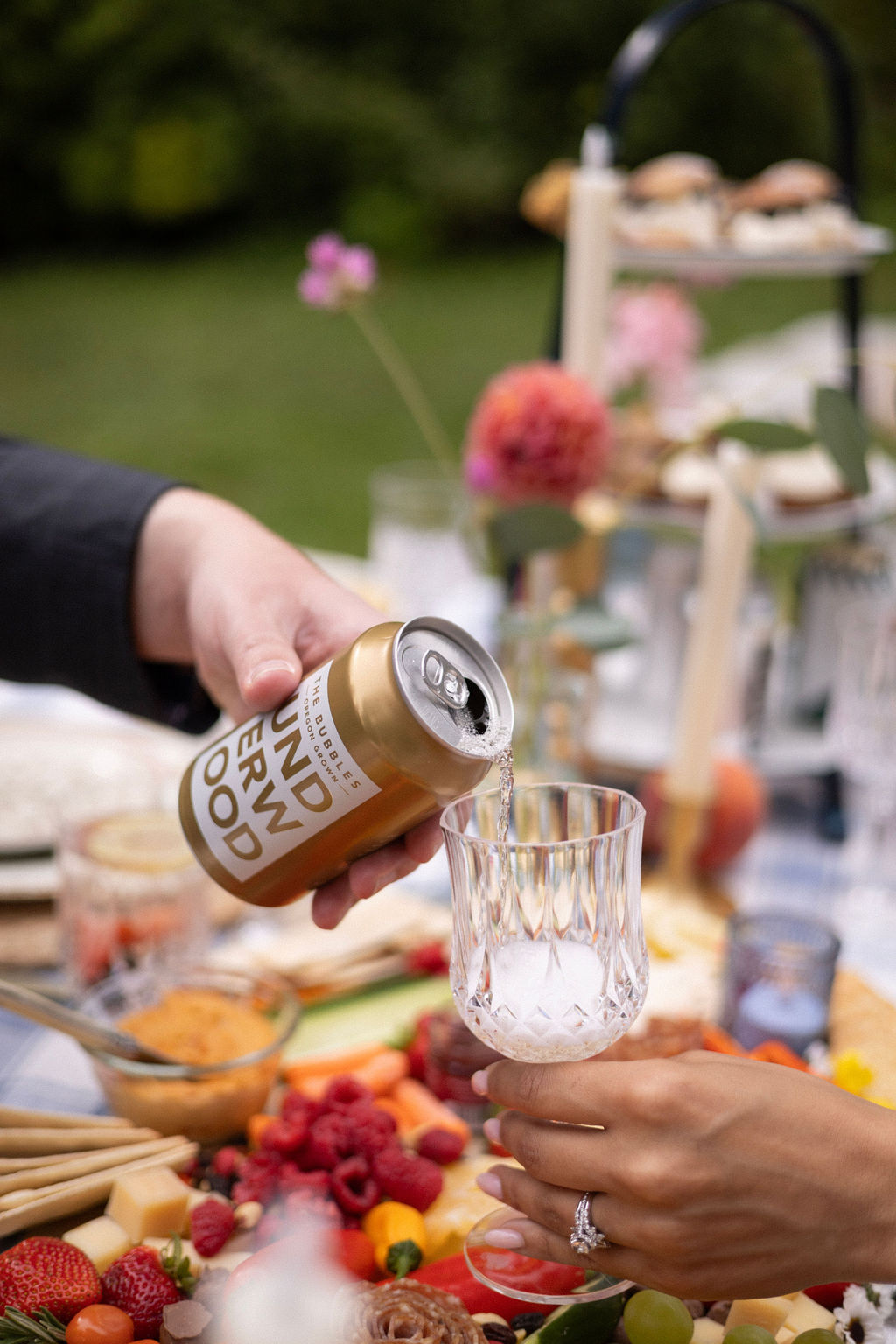 Oregon sparkling wine being poured from a can into a cut crystal glass at the picnic table