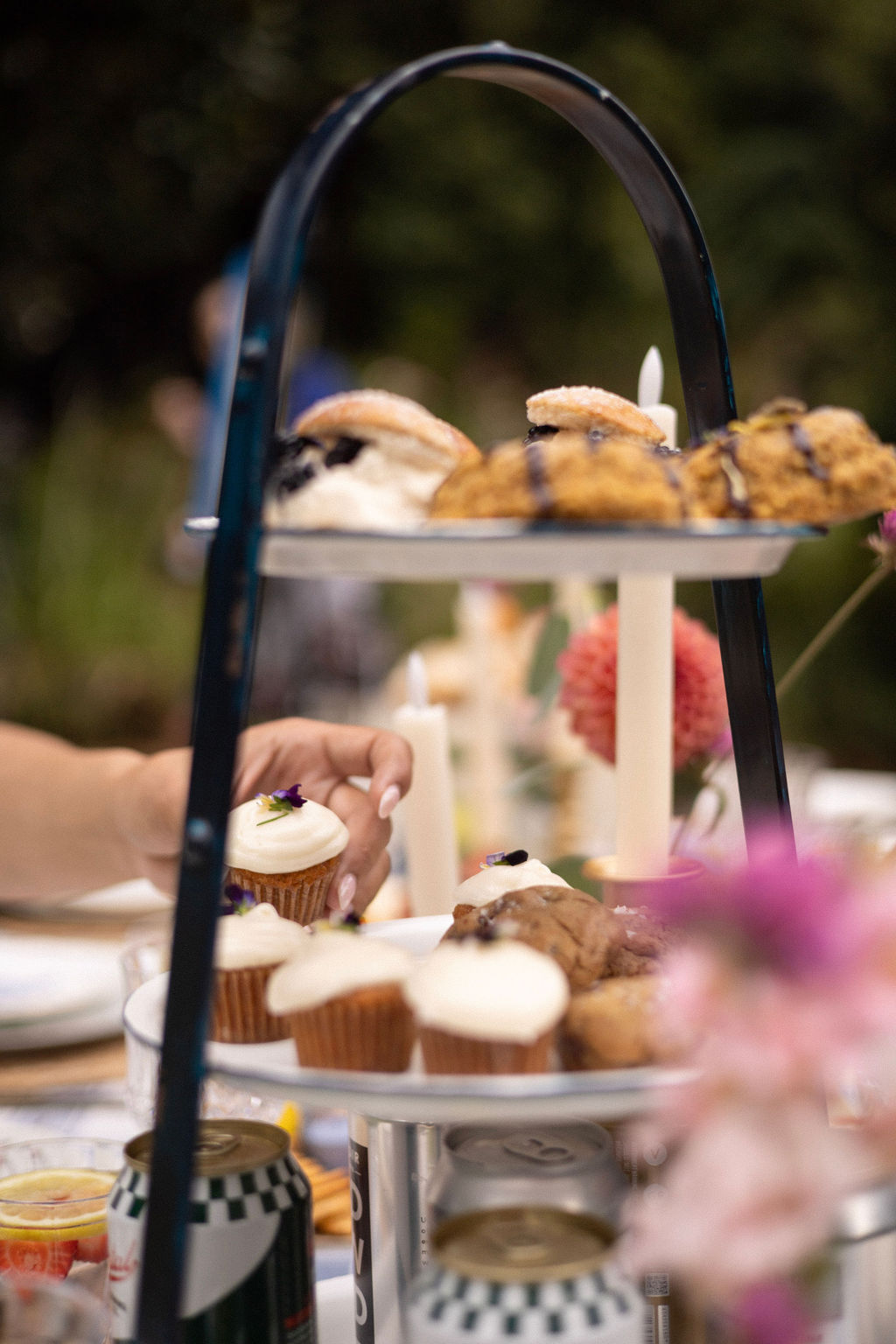 A tiered stand of cupcakes and scones from Flower and Flour on the reception table